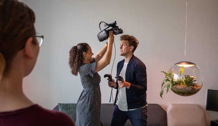 En person som hjälper en annan att sätta på ett VR-headset
